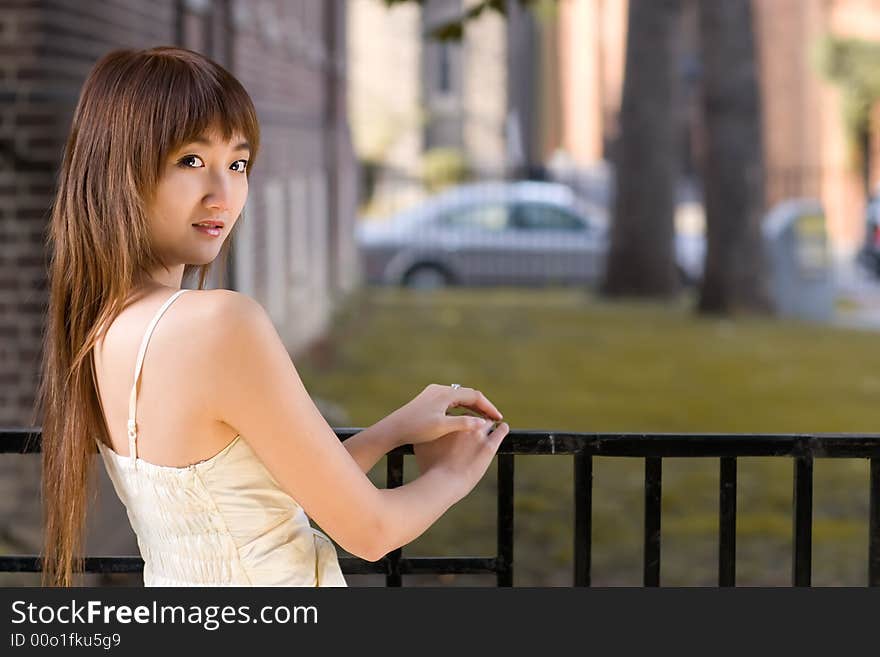 A girl looking back against metal fence on campus