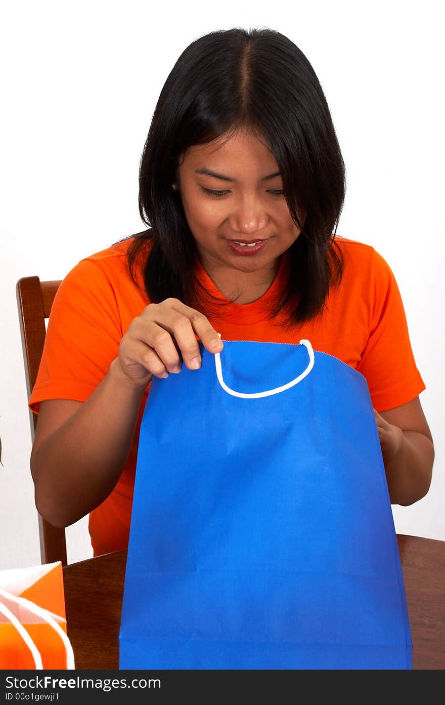 A girl looking inside the blue bag. A girl looking inside the blue bag