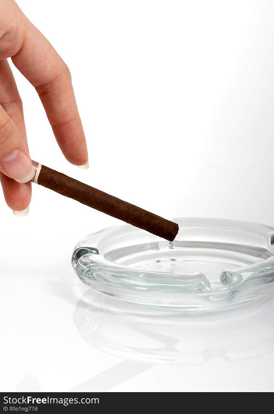 A hand holding a cigar over a white background