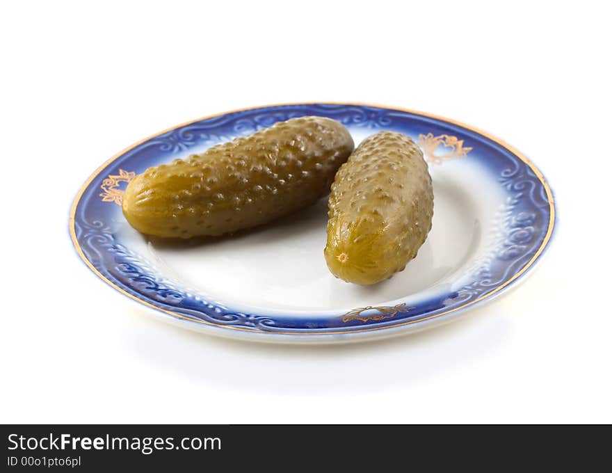 Pickled cucumbers on a plate isolated on white