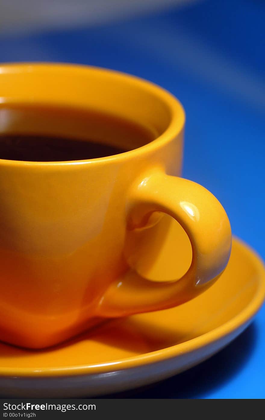 Yellow cup from coffee on a dark blue background