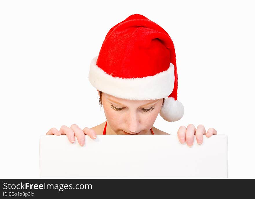 Beautiful girl in christmas bikini and with christmas hat is holding up a white sign for copy space. With background clipping path for your convenience. Beautiful girl in christmas bikini and with christmas hat is holding up a white sign for copy space. With background clipping path for your convenience