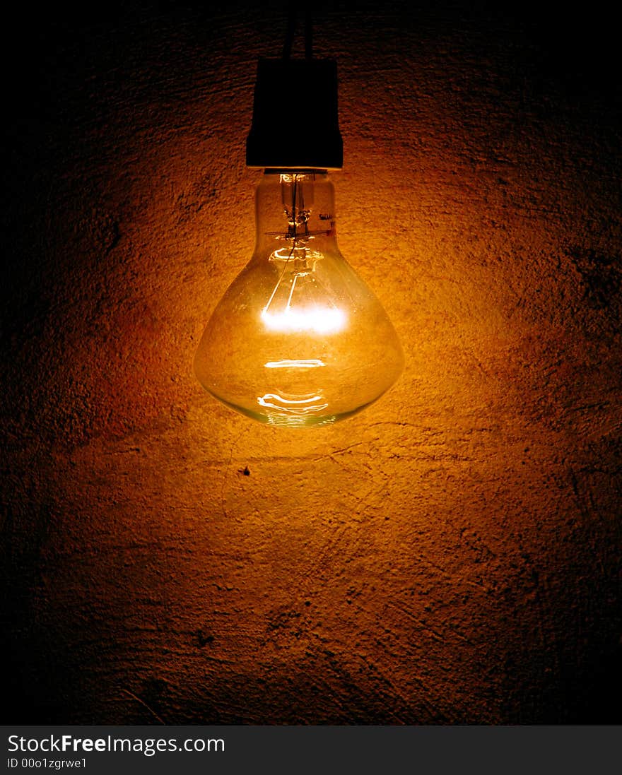 One lonely lamp on the textured wall. One lonely lamp on the textured wall