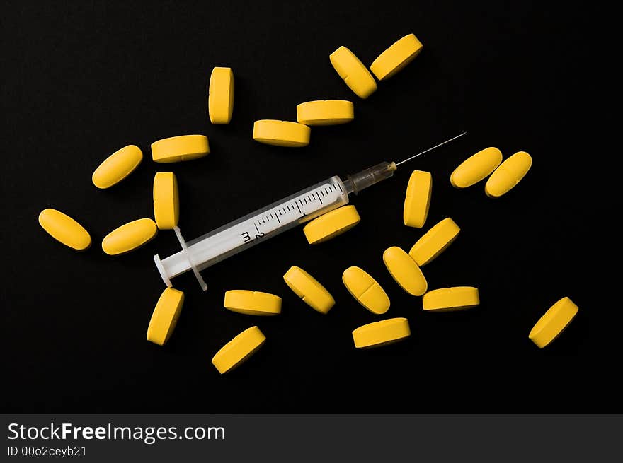 Yellow pills and syringe