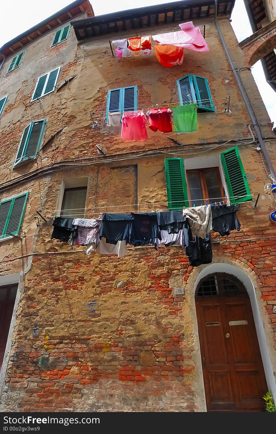 Facade of an historic building in Siena with washing for drying. Facade of an historic building in Siena with washing for drying