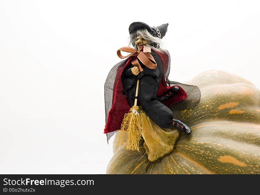 A witch with her broom on a pumpkin. A witch with her broom on a pumpkin