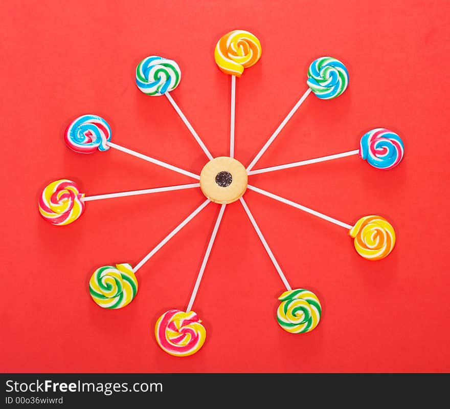 Twirl lollipop candies over a red background