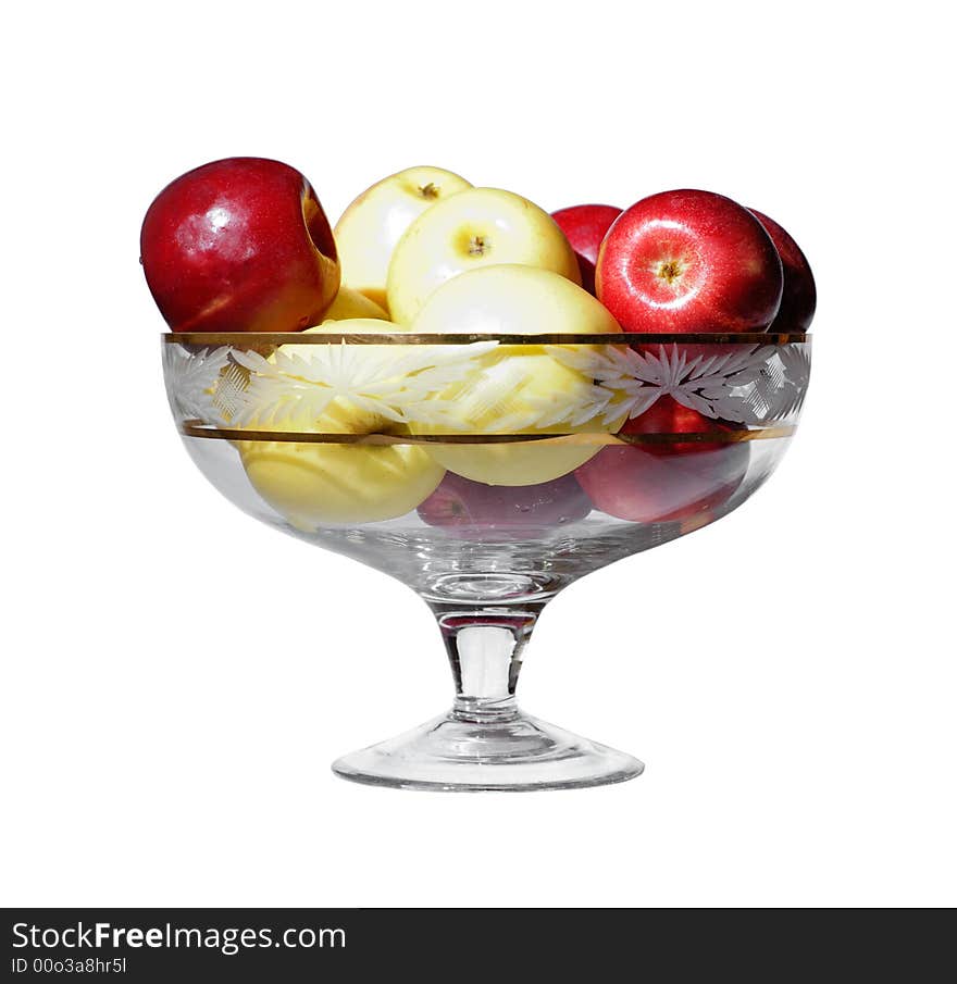 A glass vase with yellow and red apples. A glass vase with yellow and red apples