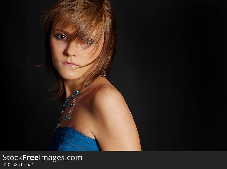 The girl in a turquoise dress and a turquoise necklace