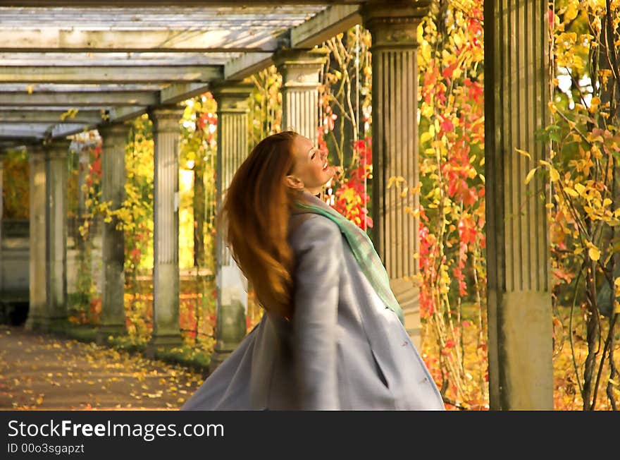 The cheerful beautiful girl in autumn park