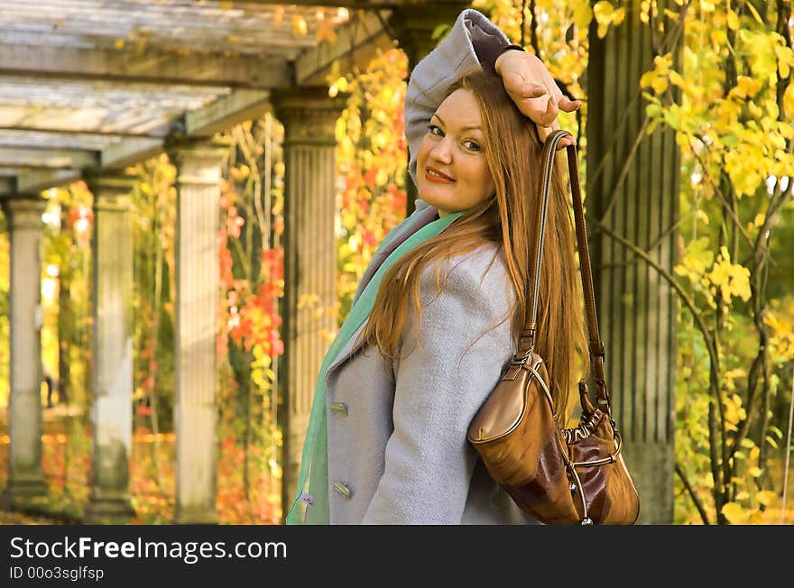 The cheerful beautiful girl in autumn park