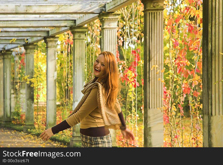 The cheerful beautiful girl in autumn park