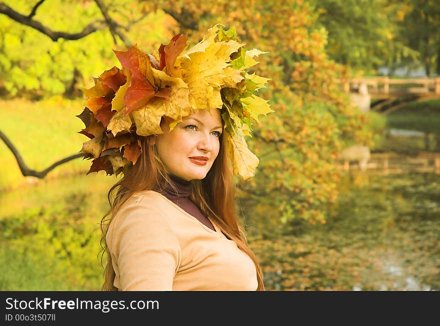 Portrait of the girl in a wreath from maple leaves