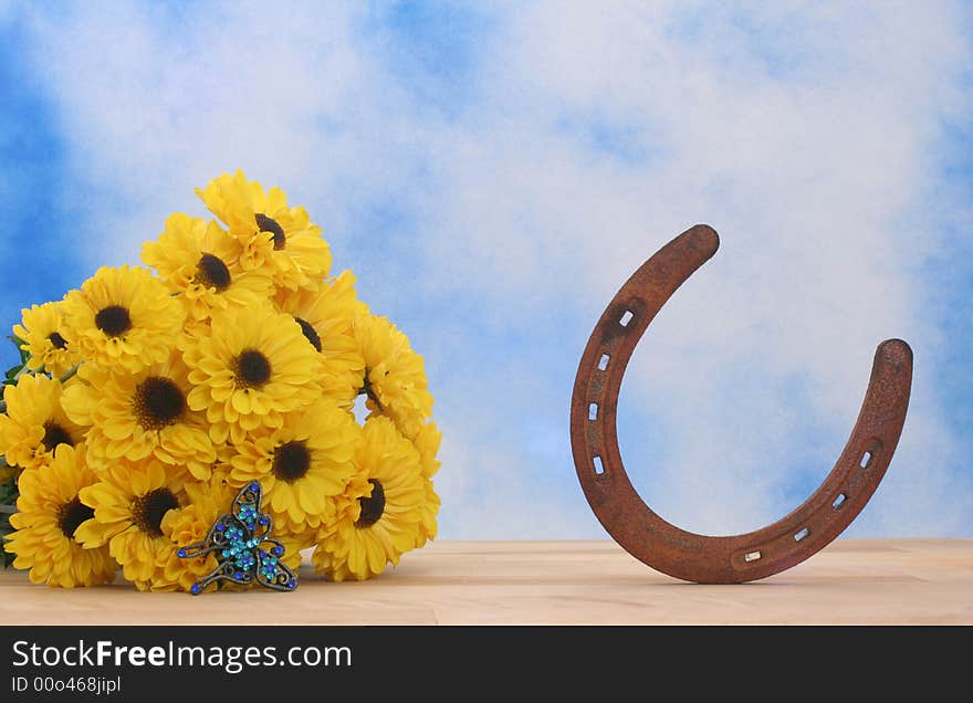 Yellow Flowers and Rusty Horseshoe on Blue and White Textured Background. Yellow Flowers and Rusty Horseshoe on Blue and White Textured Background