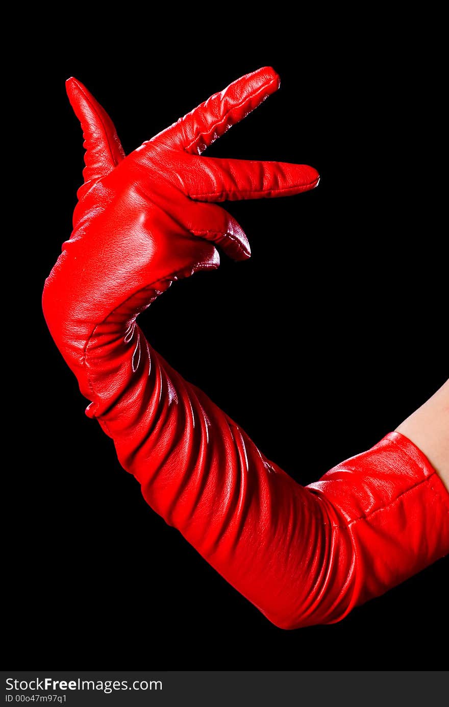 Hand in red glove on the black background counting three. Hand in red glove on the black background counting three