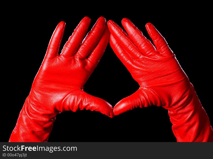 Hands in red gloves on the black background showing some signs. Hands in red gloves on the black background showing some signs