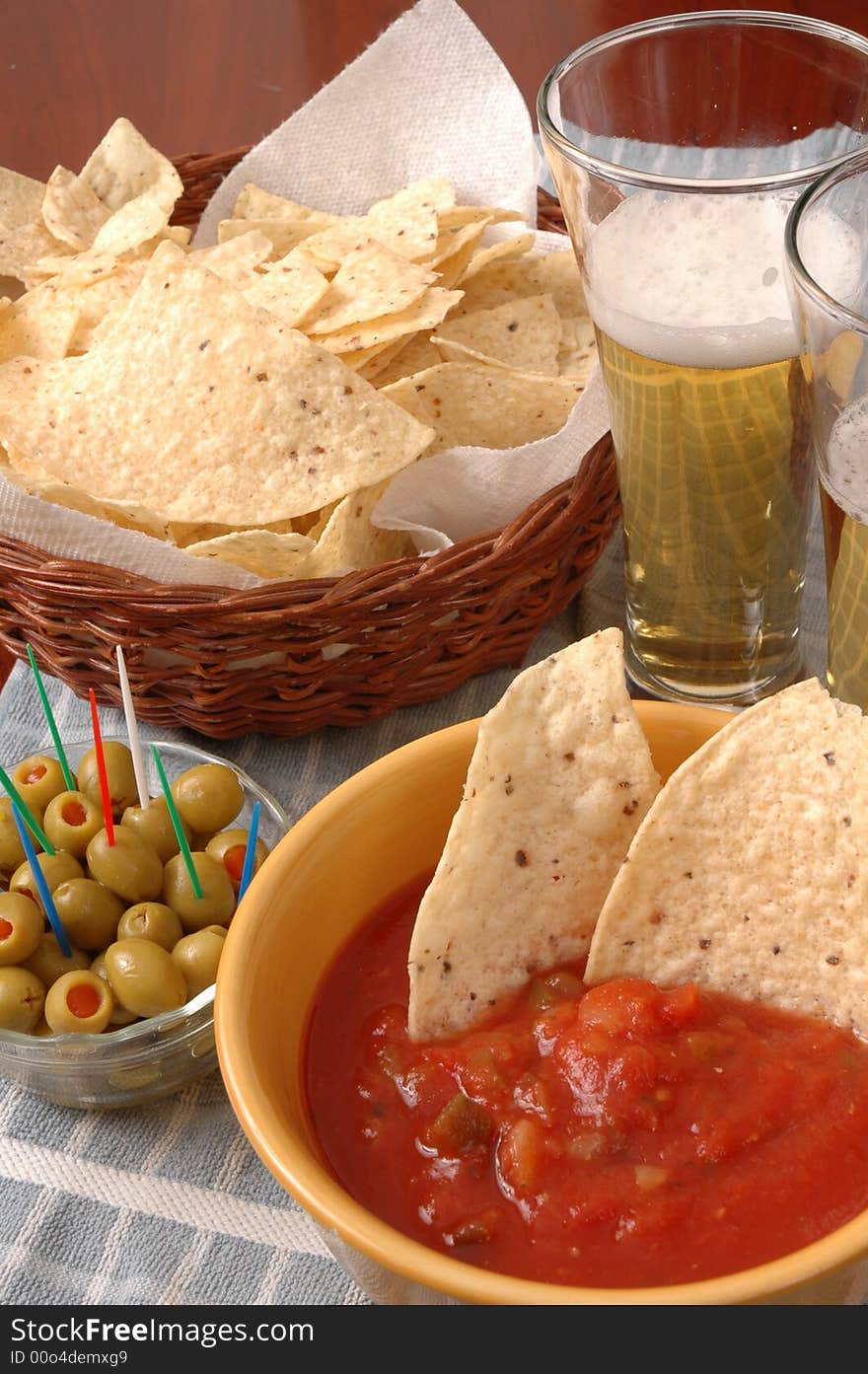 Table top with beer, chips, olives and salsa. Table top with beer, chips, olives and salsa