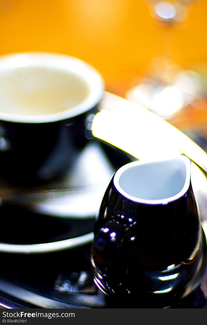 Black porcelain/china coffee cup and saucer with steaming milk coffee. Black porcelain/china coffee cup and saucer with steaming milk coffee