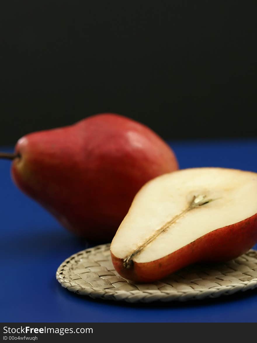 Fresh red organic pears with a blue and black background. Fresh red organic pears with a blue and black background