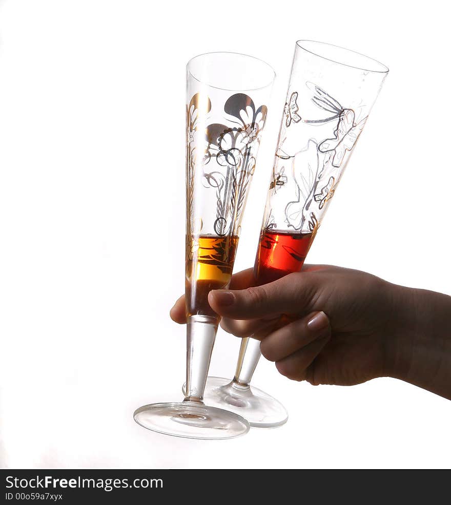 Pair of red and gold champagne flutes almost empty held by hand. Isolated on white space (for text). Pair of red and gold champagne flutes almost empty held by hand. Isolated on white space (for text).