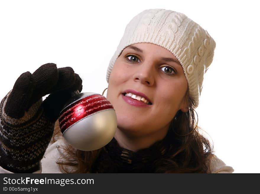 A young woman is holding christmas decoration. She is happy with winter gear on. Isolated over white with space for text. A young woman is holding christmas decoration. She is happy with winter gear on. Isolated over white with space for text.