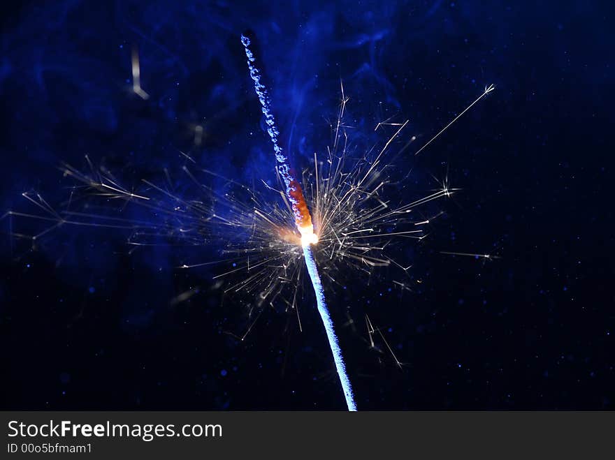 Image of burning sparkler and blue smoke