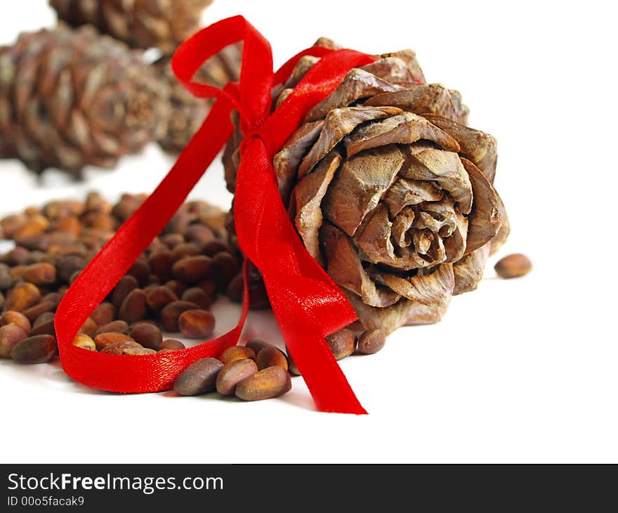 Nuts, cones and red ribbon on a white background. Nuts, cones and red ribbon on a white background