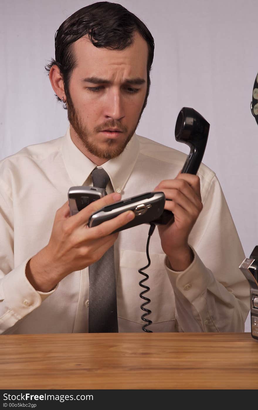 Young businessman dealing with too many phones. Young businessman dealing with too many phones