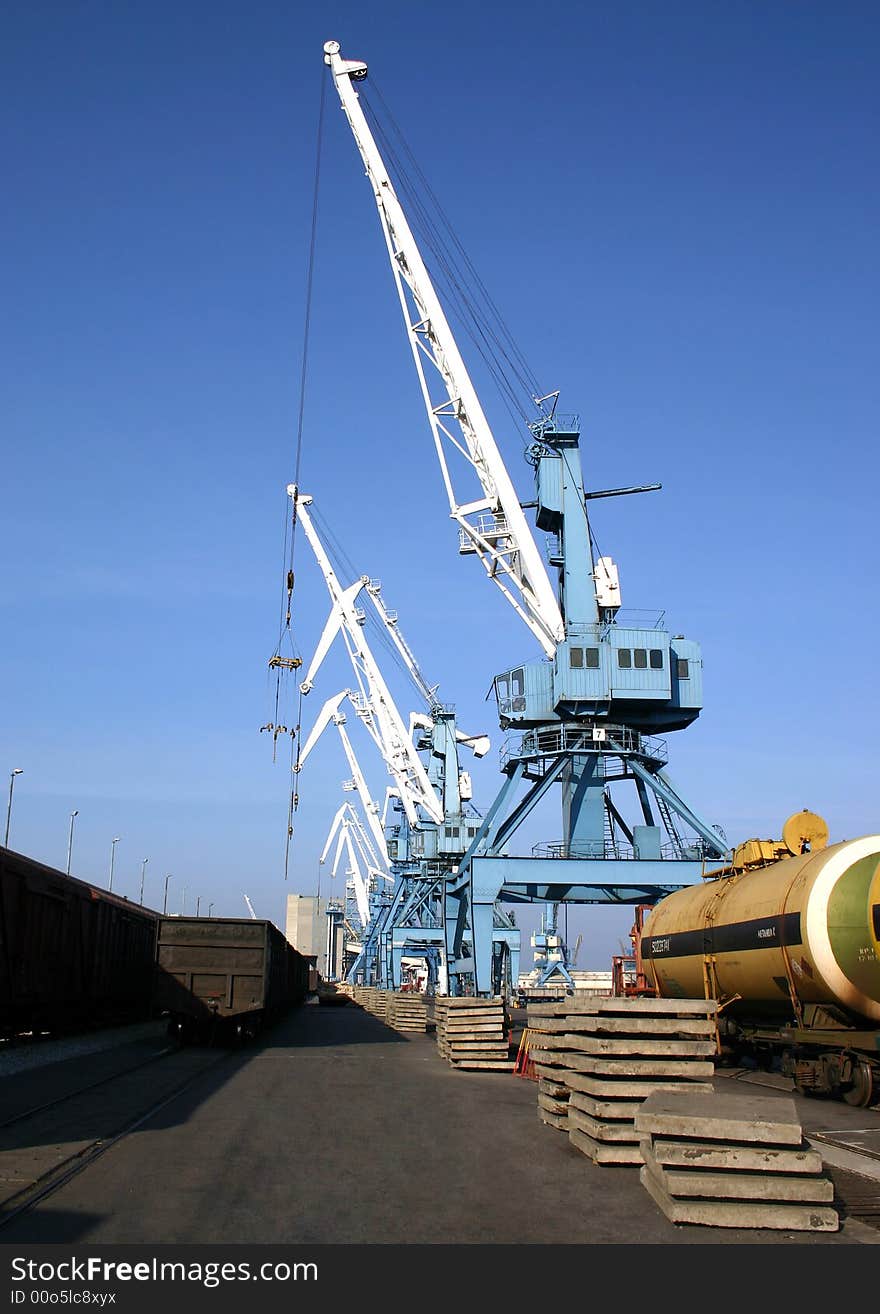 Cranes loading goods van on blue sky background. Cranes loading goods van on blue sky background