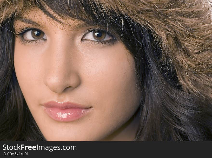 Young brunette girl in brown winter jacket.Happy face and worm look. Young brunette girl in brown winter jacket.Happy face and worm look.