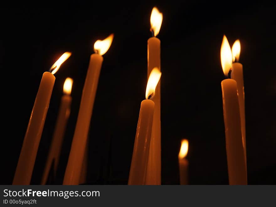 Some candles in a church agains black background. Some candles in a church agains black background