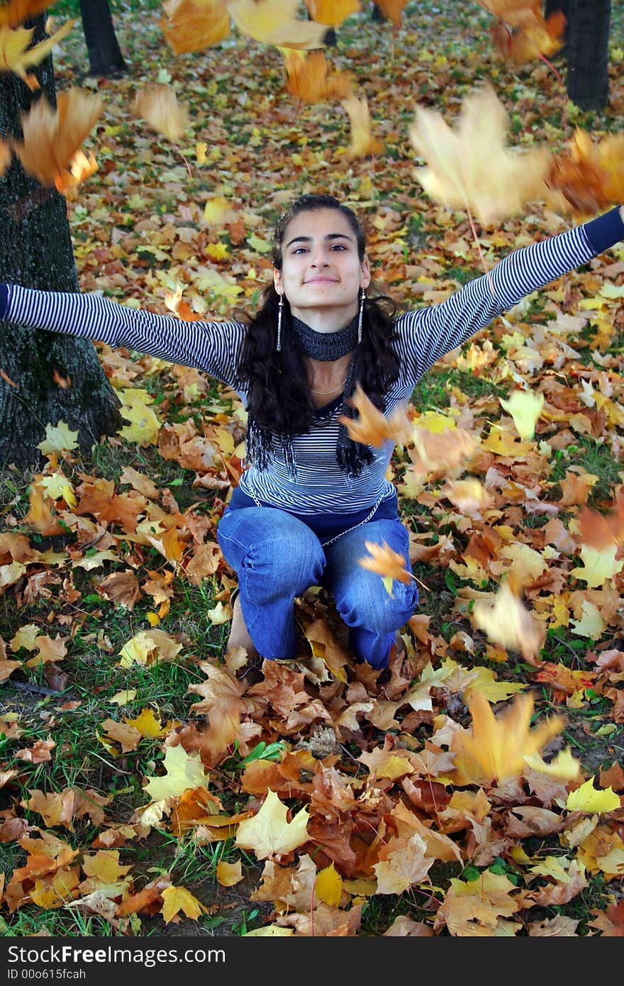 A girl throwing autumn leaves. A girl throwing autumn leaves