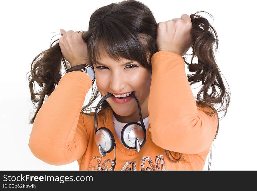 Young brunette girl with headphones in mouth making funny hair style. Young brunette girl with headphones in mouth making funny hair style.