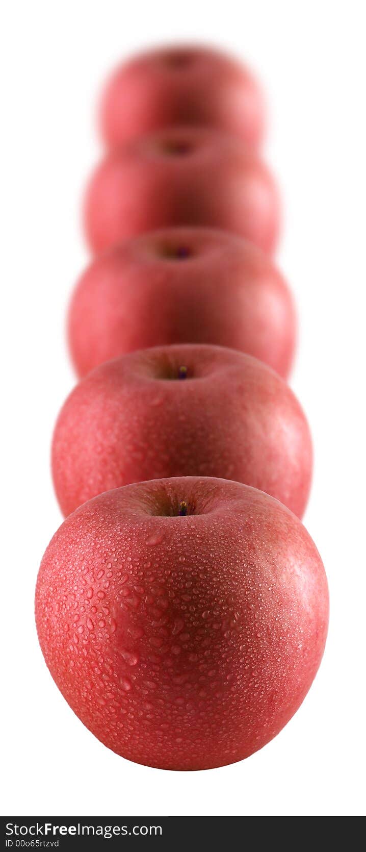 A row of red apples sprinkled with water