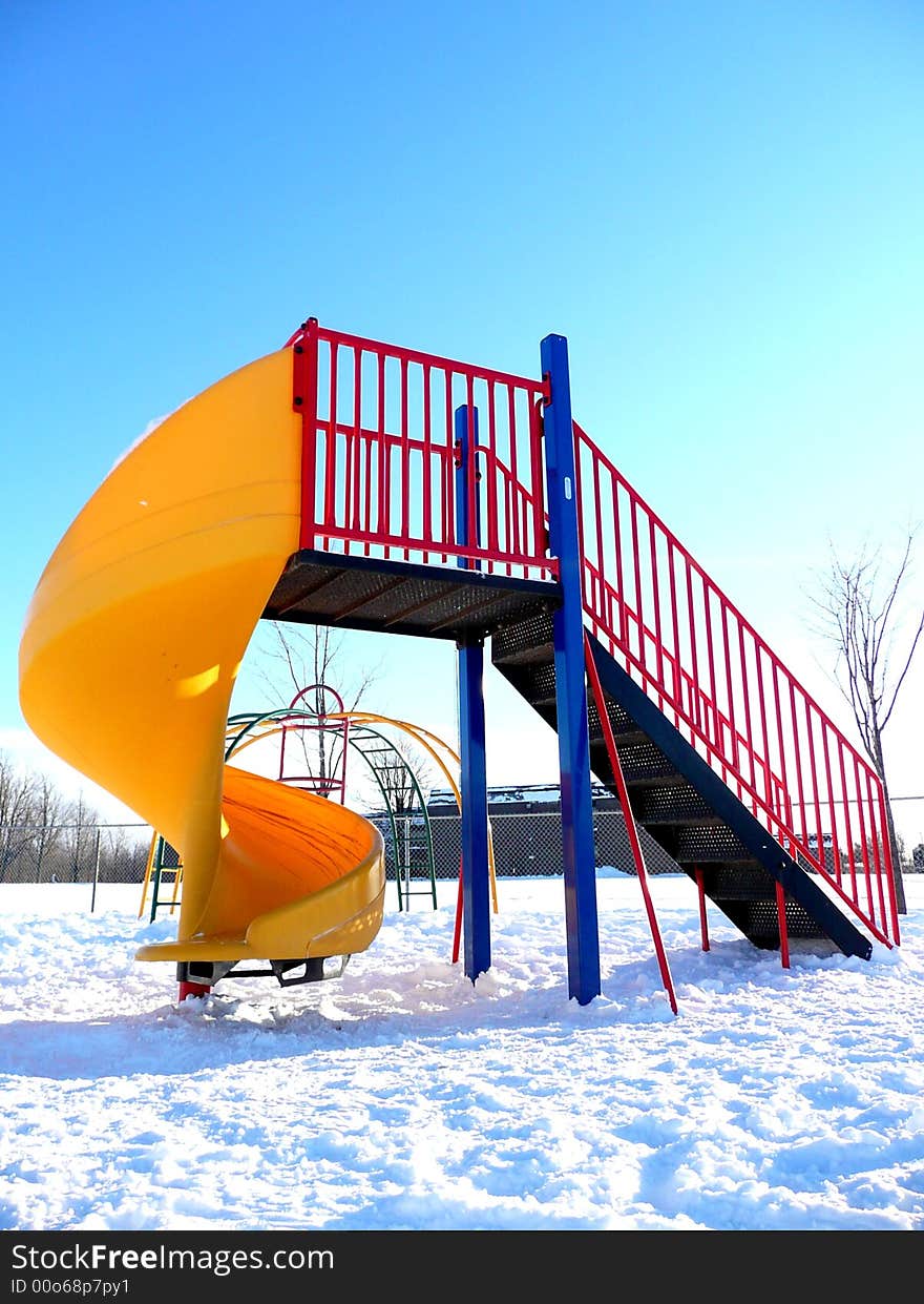 Children's playground covered in snow and vacant. Children's playground covered in snow and vacant