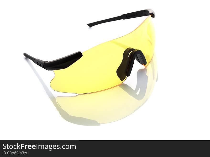 Yellow protective glasses isolated on white. Subtle reflection beneath.