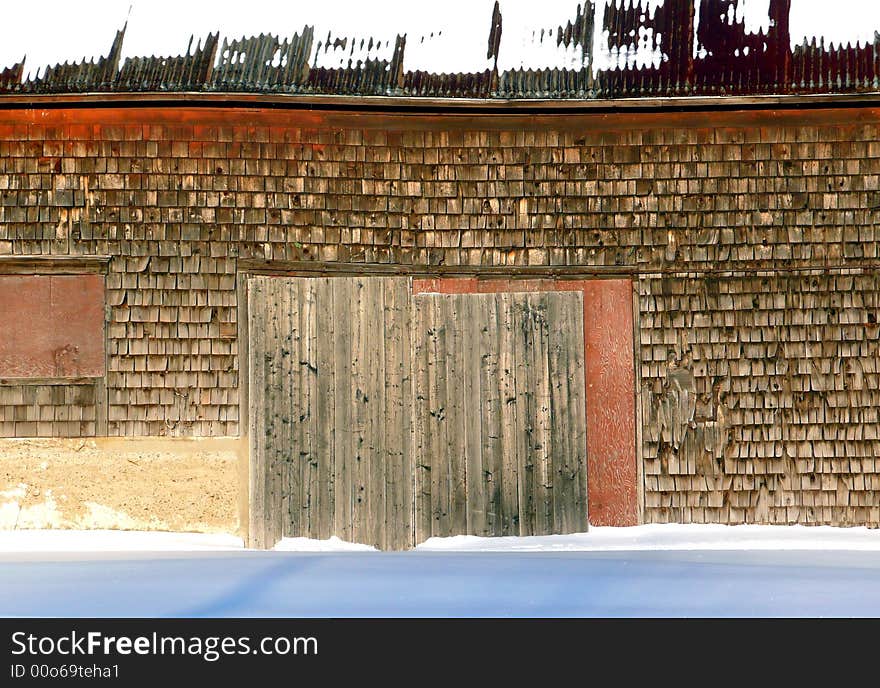 Old abandoned barn-like building warping in the snow