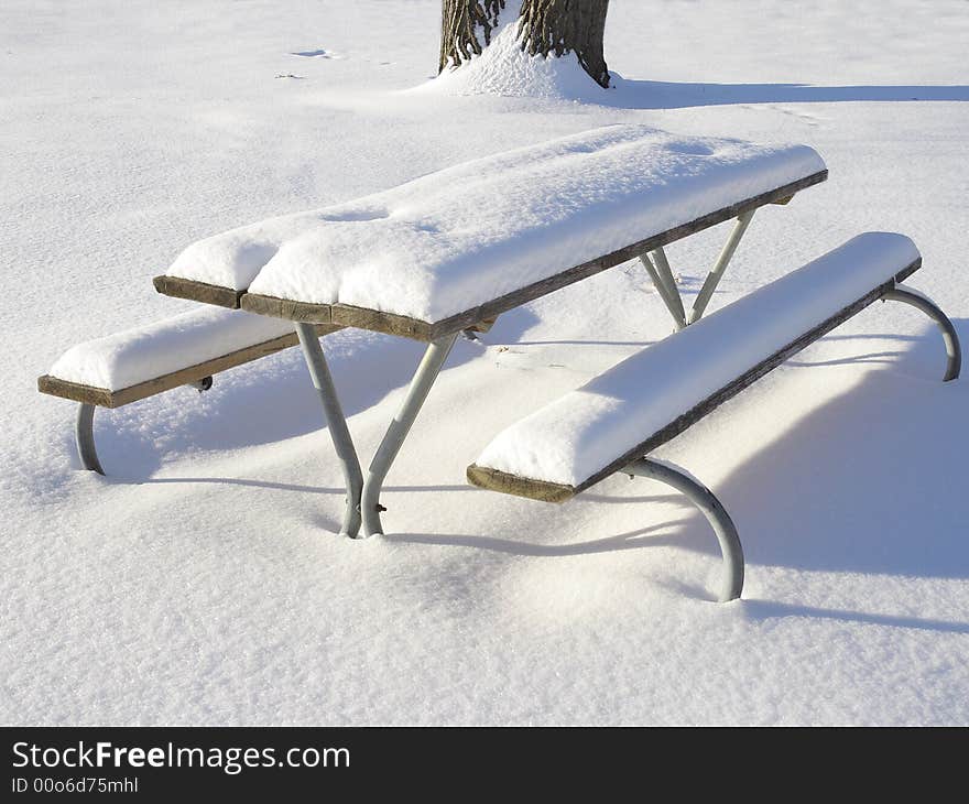 Winter in the park, fresh snow on the picnic table