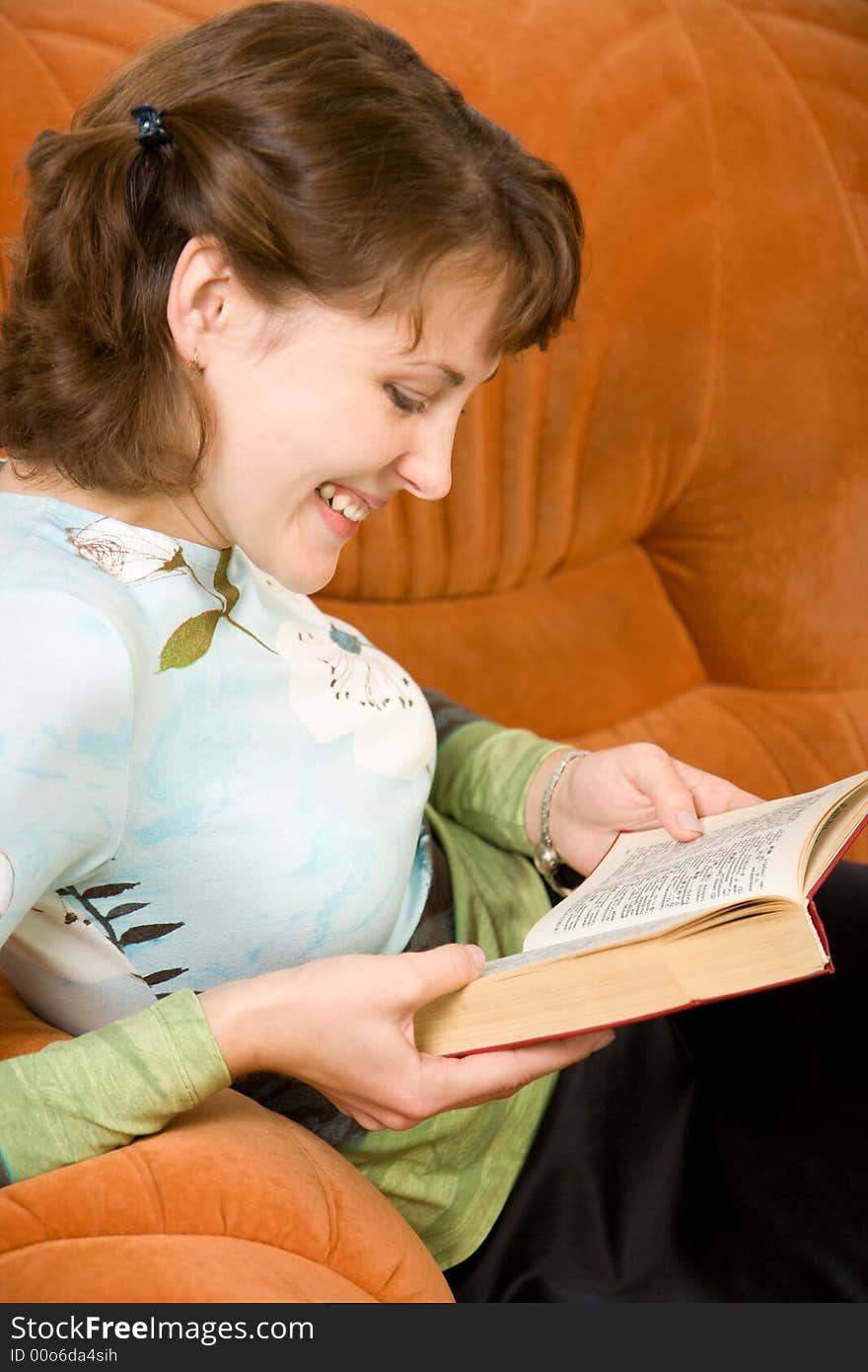 Young smiling girl reading book