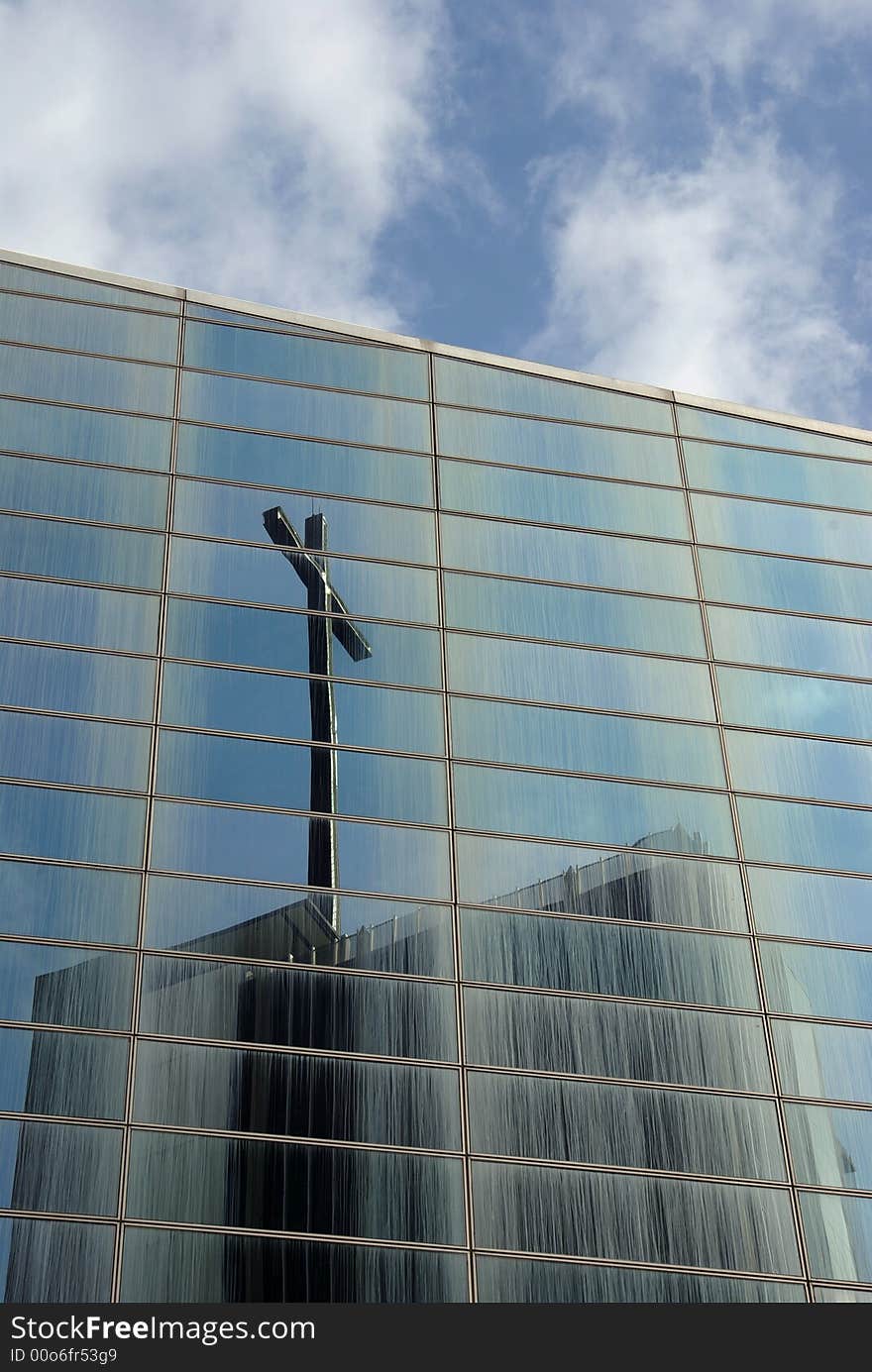 Christian cross reflected in glass panels of building. Christian cross reflected in glass panels of building