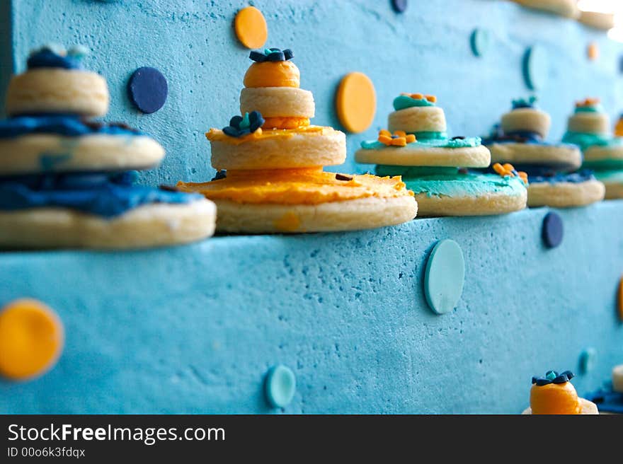 An image of up close decorated cookies on top of a gourmet cake