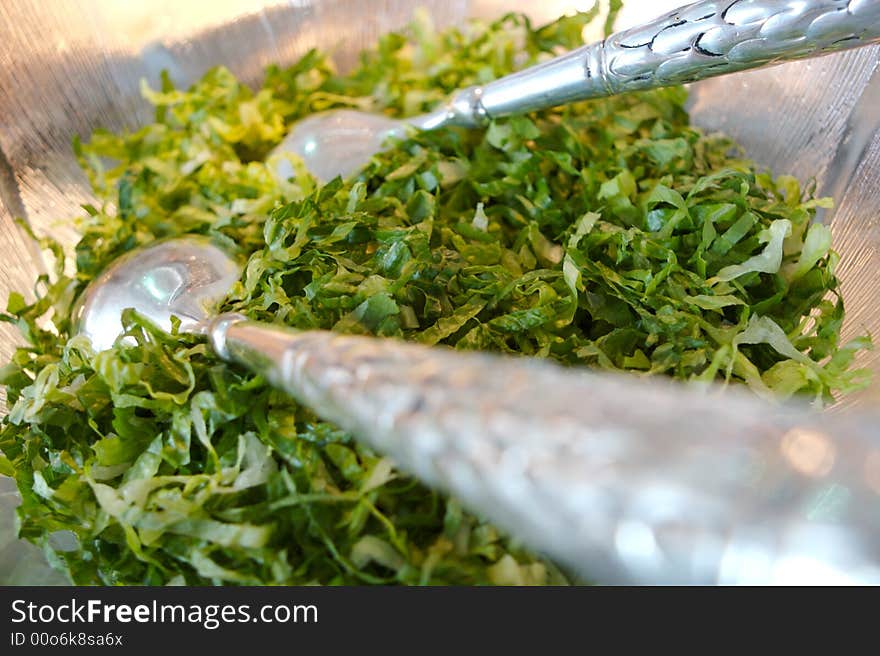 Cut salad in bowl with utensils