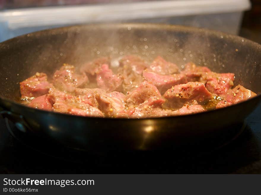 Beef tenderloin pieces grilling in a frying pan