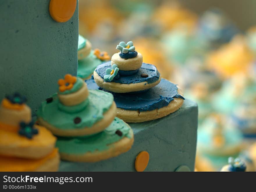 An image of decorated cookies on top of a beautiful wedding cake. An image of decorated cookies on top of a beautiful wedding cake