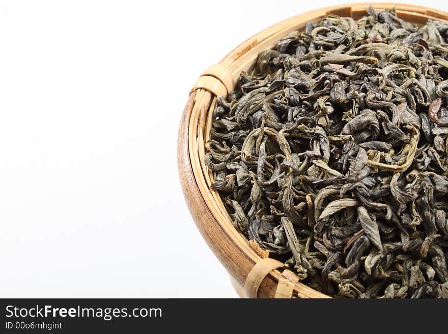 Green tea leaves in a bamboo tea strainer.