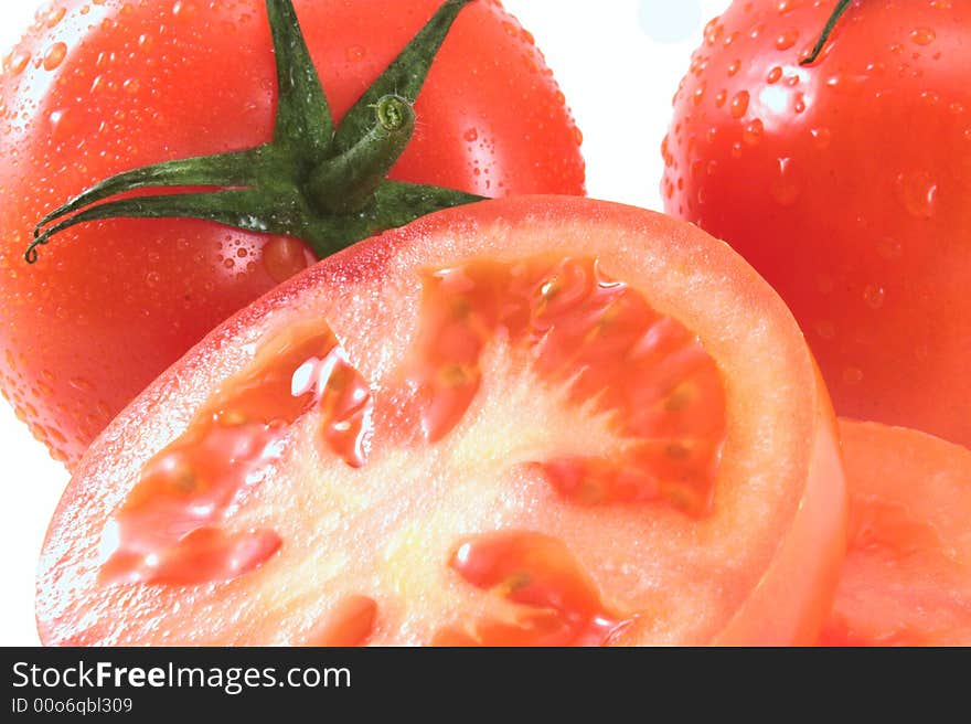 Ripe juicy tomatoes isolated on white; wet. Ripe juicy tomatoes isolated on white; wet