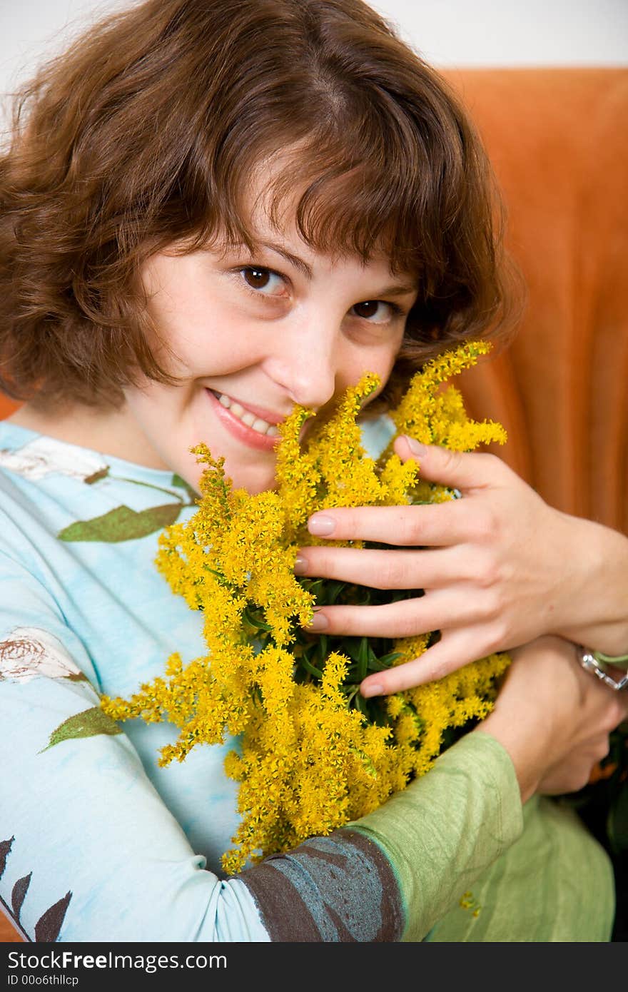 Young girl with flowers sitting on sofa