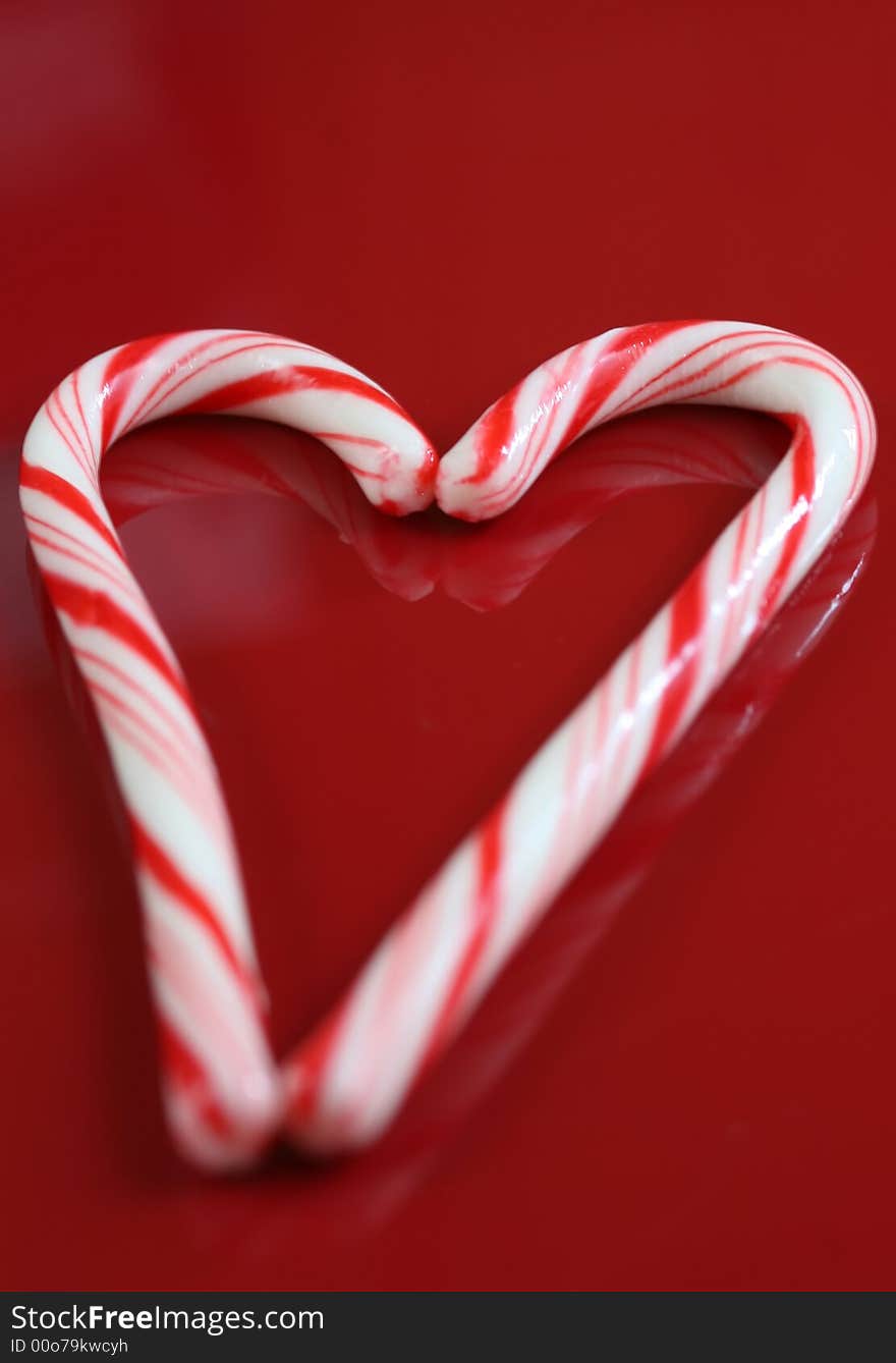 A christmas candy cane heart on a red background. A christmas candy cane heart on a red background