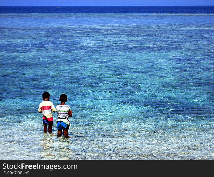 Two boys fishing on Mabul island in Borneo. Two boys fishing on Mabul island in Borneo.