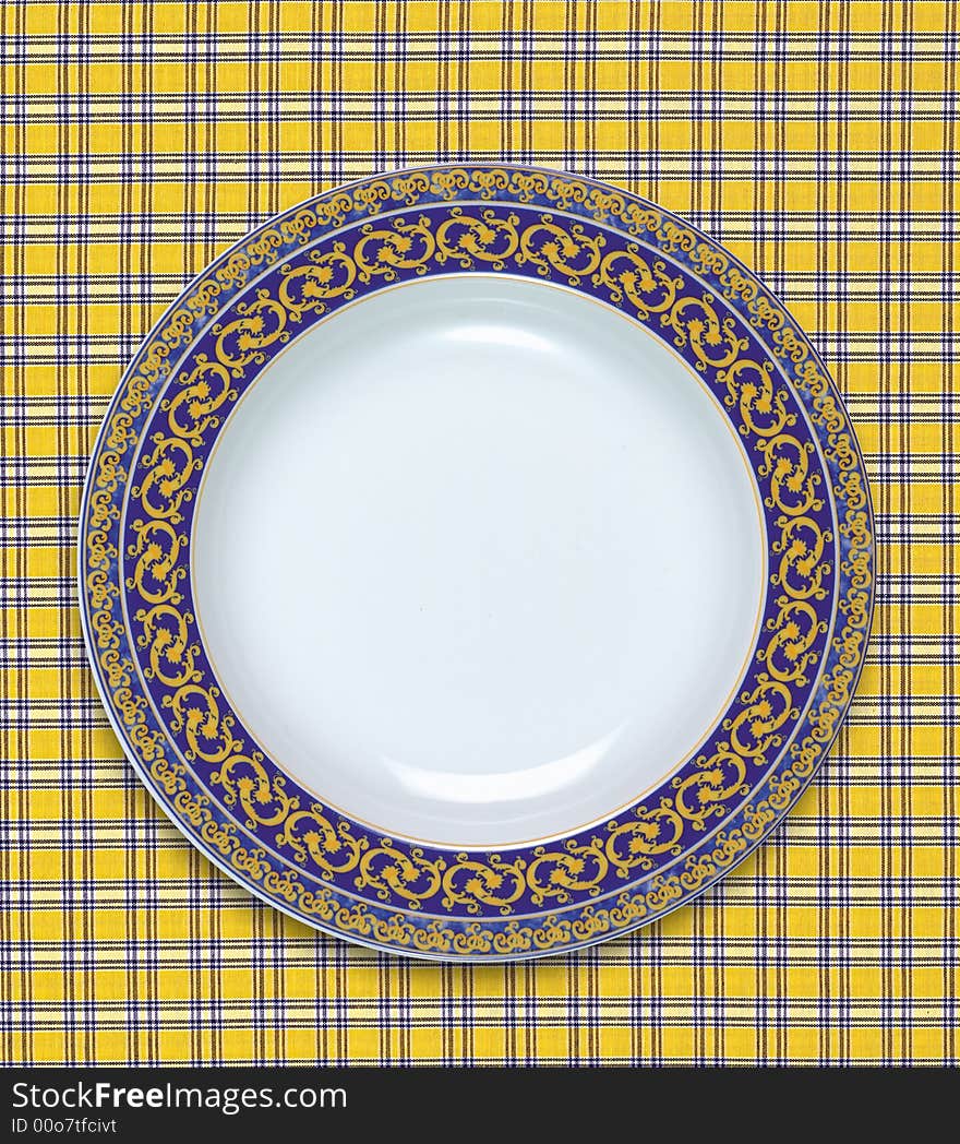 A empty dish on the table cloth